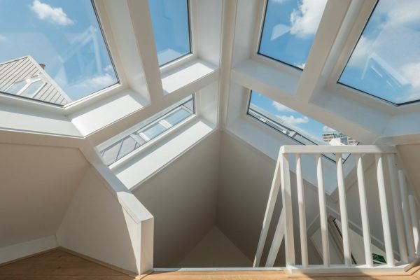 Inside the Cube House. View to the stairs leading down and blue sky through the windows on the roof